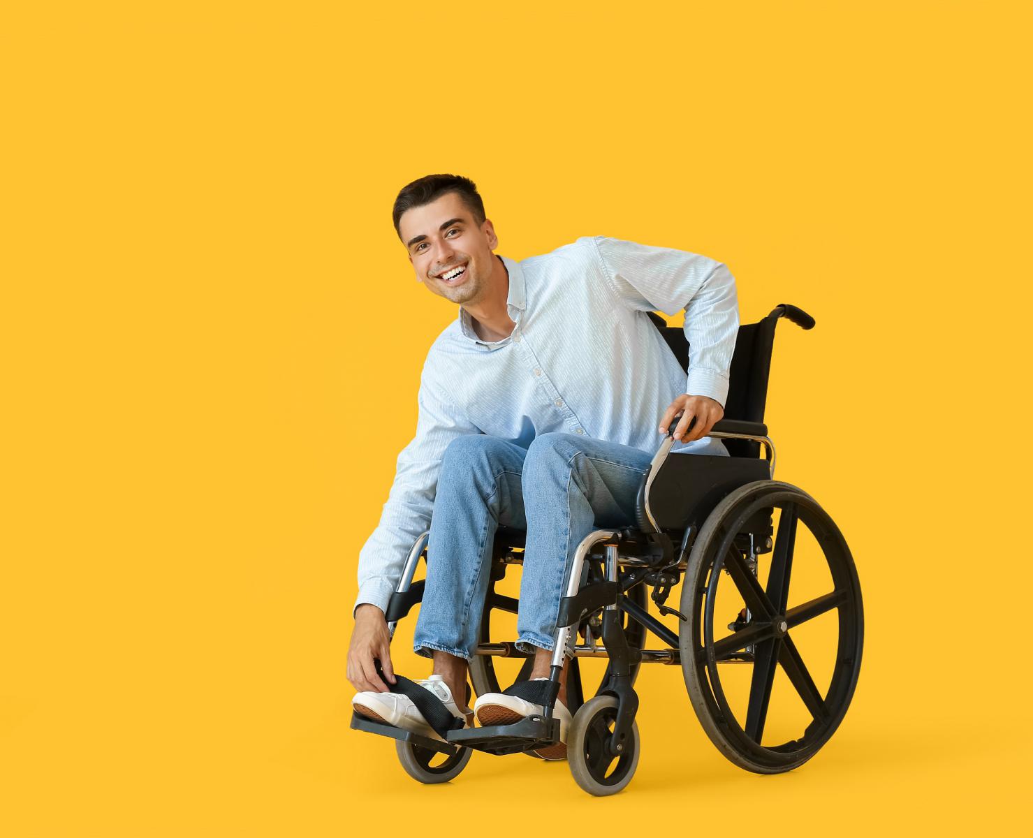 Image of a man smiling and sitting in a manual wheelchair.